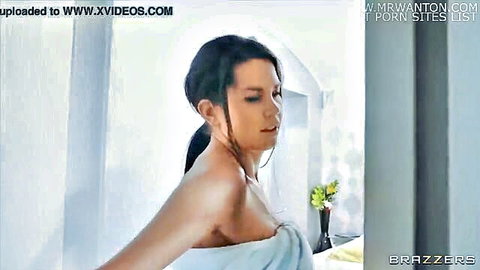 Brunette beauty wrapped in white towel, teasing in bathroom