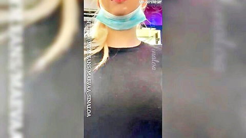 Blonde babe in blue mask selfie with puckered lips in purple lit store
