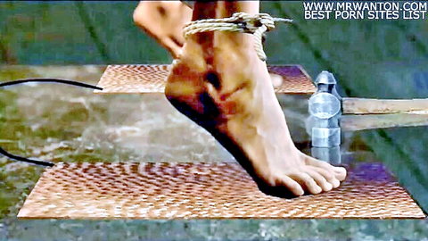 Bound female foot in BDSM torture setup with hammer and electro pads