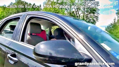 Granny in red top teased in public car backseat with young stud through tinted window