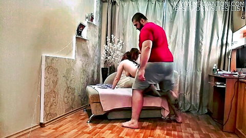 Muscular guy fucks redhead girl's exposed pussy doggy style from behind on couch