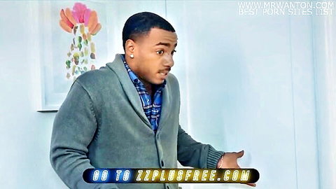 Handsome black man in gray cardigan and blue plaid shirt standing surprised in bedroom