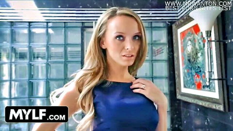 Blonde MILF with big tits in shiny blue dress posing seductively