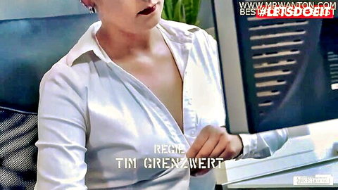 Brunette secretary unbuttons white blouse revealing deep cleavage and big tits in office