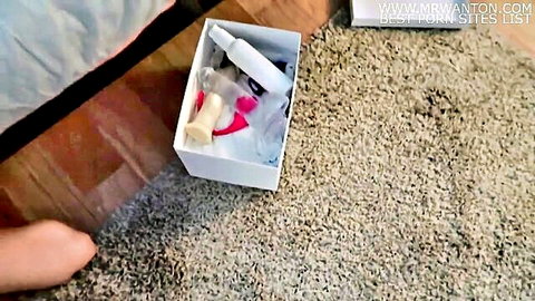 Amateur sex toy box on bedroom floor with woman's foot visible