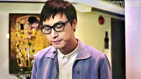Handsome Asian man in glasses and purple jacket smiling seductively in indoor setting