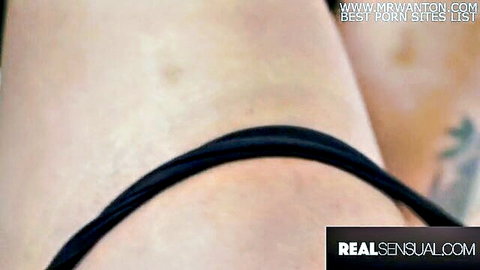 Close-up of pale babe's curvy thigh and ass cheek in tight black thong straps with sexy tattoo