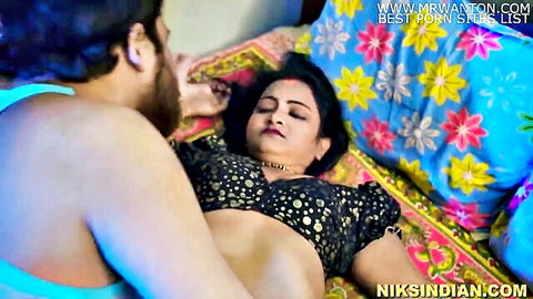 Indian bhabhi in black blouse lying on bed as neighbor touches her intimately