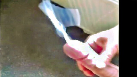 Close-up hand holding erect penis with semen ejaculation