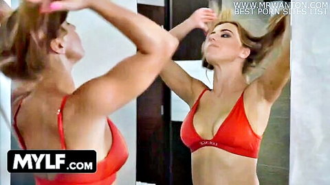Blonde MILF in red lingerie posing seductively in mirror