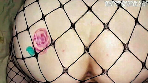 Big juicy ass in black fishnet stockings with pink rose tattoo on butt cheek closeup