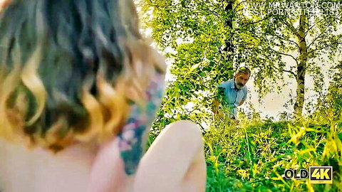 Mature guy approaches nude young woman from behind in sunny forest
