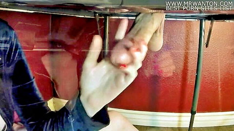 Pale hand grips and strokes massive erect cock under glass table with red scratches