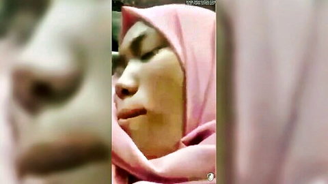 Sensual close-up of Malay woman in pink hijab, soft breasts implied