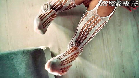 Skinny babe in crotchless white fishnet stockings spreads legs exposing shaved pussy closeup