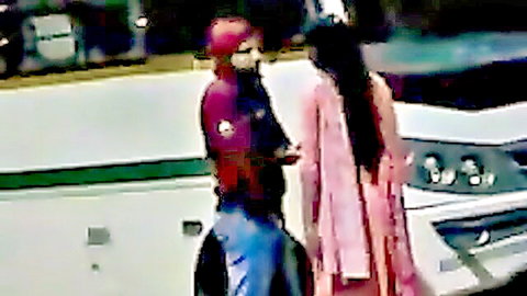 Sexy Bangla couple flirting outdoors, woman in pink dress by bus