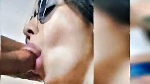 Asian woman with sunglasses sucks thick black cock, lips wrapped around the shaft