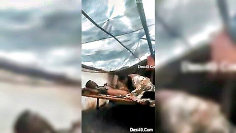 Blurry desi Indian couple having sex on wooden cot under tent roof