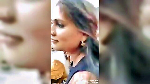 Seductive Indian woman with blue hair and gold earrings smiles erotically in close-up