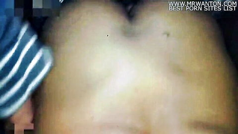 Close-up of woman's pale ass cheeks spread exposing tight pink anus with striped shorts aside