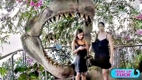 Mina Sauvage and friend in black dresses posing by giant shark jaw, threesome tease