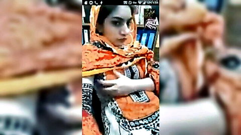 Sexy Pakistani hijabi girl in orange dupatta smiling teasingly on webcam