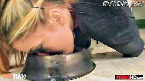 Blonde slut kneels with face buried in metal dog bowl exposing bare ass in BDSM pet play
