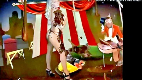 Blonde Howard Stern model in skimpy circus straps, seductive pose