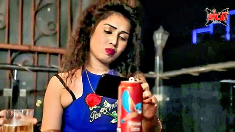 Curvy Indian woman in sexy blue top holding drink seductively