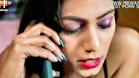 Seductive Indian woman on phone call with heavy makeup and cleavage