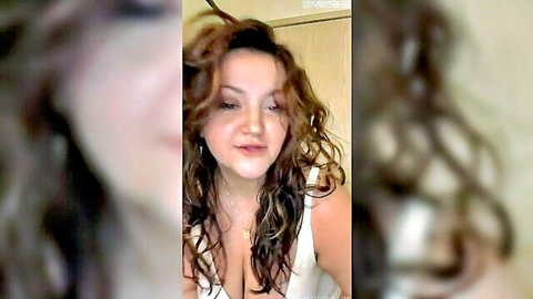 Curvy MILF with big cleavage and curly brown hair in low-cut top