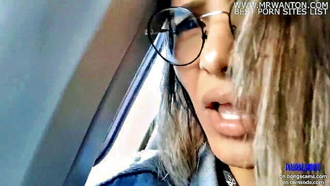 Blonde woman with glasses in car, teasing outdoor masturbation