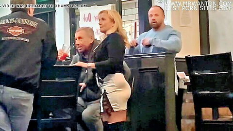 Trashy blonde MILF GILF bar slut in short skirt and boots with men
