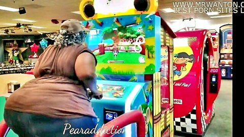 Big black BBW with huge ass playing arcade game in tight dress