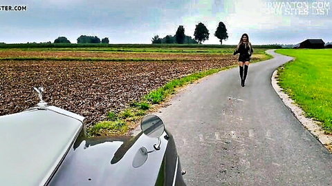 Sexy blonde in tight mini skirt and thigh-high boots running outdoors by luxury car
