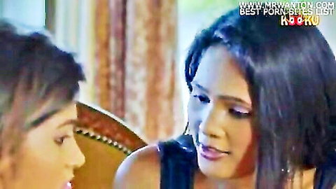 Two sexy Indian women in tight black top sitting close intimately teasing taboo scene