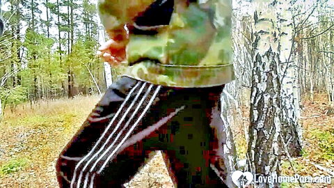 Amateur stepmom in camo jacket and Adidas pants walking in forest