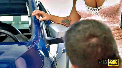 Tanned babe in revealing pink lace dress grabs man's head leaning into blue car for blowjob tease