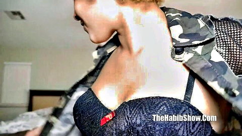 Blonde babe teases with massive tits spilling from black lace bra under open camo jacket