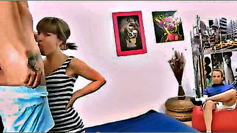 Muscular tattooed guy kissing young long-haired brunette's neck in striped dress while boyfriend watches