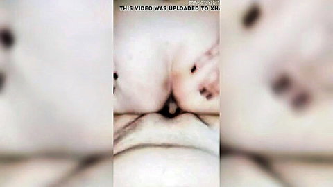 Blurry closeup of pale woman's ass cheeks spread by hand revealing tight pink anus