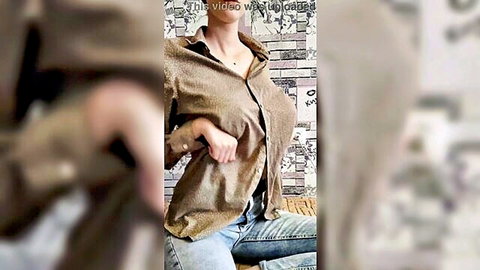 Busty woman in unbuttoned shirt exposing large breasts, sitting casually