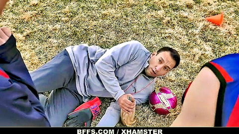 Older coach surprised on soccer field by cute teens in uniforms