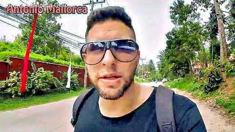 Antonio from Mallorca in sunglasses, walking outdoors in Thailand with backpack