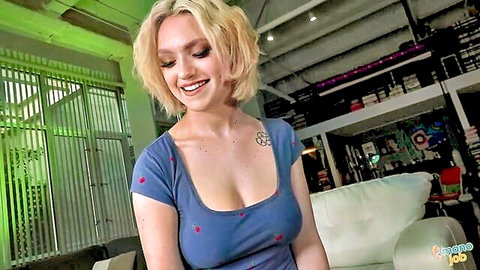 Gracie Gates smiling in low-cut blue dress, teasing cleavage
