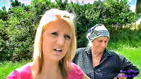 Blonde teen with open mouth faces mature granny in headscarf outdoors lesbian tease