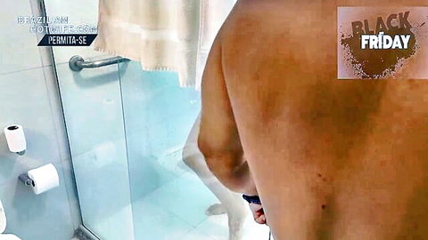 Naked muscular man bare ass entering glass shower door in tiled bathroom