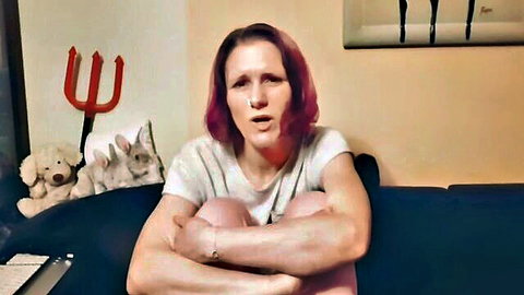 Pink-haired freckled MILF sits arms crossed on couch in amateur homemade video