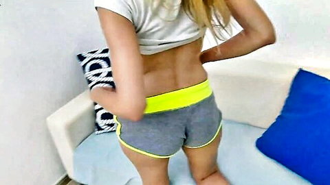 Skinny blonde teen teases her firm ass in tight gray shorts bending over couch