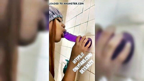 Ebony beauty sucking purple dildo in shower